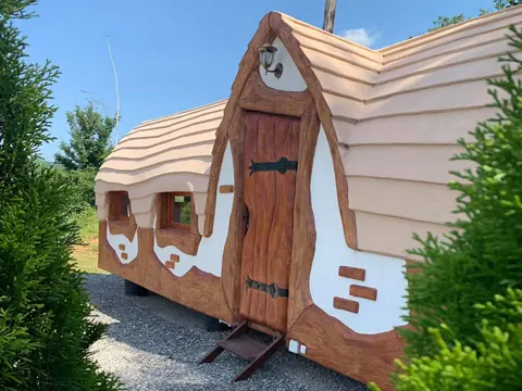 Steep A-frame gnome house with sculpted timber details