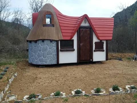Cottage with a stone base, cream walls and a bright red roof